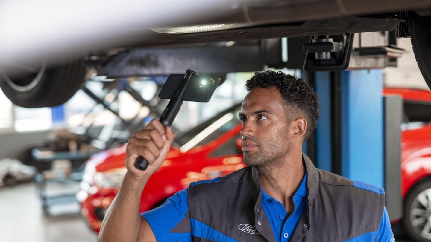 Ford Service engineer, inspecting underneath vehicle